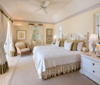 Charming guest bedroom with soft neutral tones, elegant décor, and garden views at Benjoli Breeze, Barbados.