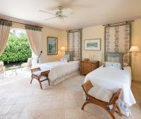 Beautifully designed twin bedroom with soft blue and cream accents, garden views, and direct outdoor access at Benjoli Breeze, Royal Westmoreland.