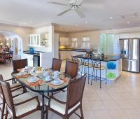 Modern, fully-equipped kitchen with breakfast dining area at Benjoli Breeze, a luxury villa rental in Royal Westmoreland, Barbados.
