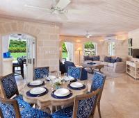 Elegant open-plan dining and living area at Coconut Grove 2, showcasing coral stone walls, stylish decor, and seamless indoor-outdoor Caribbean living.
