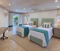 Twin guest bedroom at Coconut Grove 2, perfect for families, with plush bedding, coastal-inspired decor, and direct access to the garden patio.