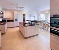 Modern and fully equipped kitchen at Howzat Villa, Barbados, featuring sleek appliances, a spacious island, and elegant finishes.