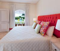 Stylish guest bedroom in the cottage at Howzat Villa, Royal Westmoreland, featuring a king-size bed, vibrant decor, and lush tropical views.