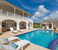 Stunning infinity-edge pool and sun loungers at Howzat Villa, Royal Westmoreland, Barbados, offering a private oasis with panoramic golf course views.
