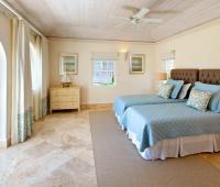 Beautifully furnished twin bedroom at Howzat Villa, Barbados, offering a cozy retreat with elegant decor and natural light.
