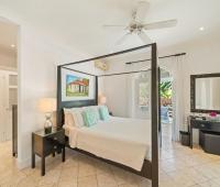 Spacious bedroom with a king-sized bed, stylish décor, and access to a private patio at Ixora, Royal Westmoreland, Barbados
