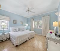 Cozy bedroom with two twin beds, tasteful décor, and ample natural light at Ixora, Royal Westmoreland, Barbados