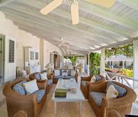 Outdoor sitting area with comfortable seating and beautiful views of tropical gardens at Ixora, Royal Westmoreland, Barbados