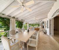Elegant indoor dining area with spacious layout, modern decor, and large windows offering views of the outdoor pool area at Ixora Royal Westmoreland, Barbados