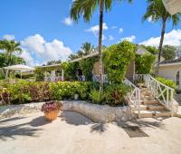 Stairs leading to the elevated dining area with a stunning view of the pool and gardens at Ixora Royal Westmoreland, Barbados
