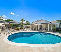 Beautiful pool deck featuring a crystal-clear pool and elegant outdoor seating area, surrounded by tropical greenery at Ixora Royal Westmoreland, Barbados