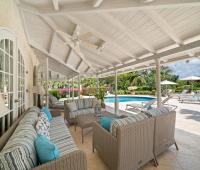 Cozy outdoor seating area with plush cushions and tropical views, perfect for relaxing by the pool at Ixora Royal Westmoreland, Barbados