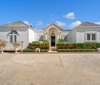 The elegant front entrance of Ixora Villa at Royal Westmoreland, framed by lush gardens and tropical plants