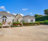 Another view of the grand entrance of Ixora Villa, with vibrant landscaping and a welcoming pathway leading to the villa