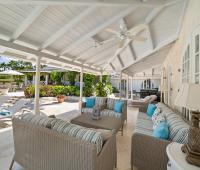 Serene outdoor seating area with comfortable furniture, located near the pool and surrounded by tropical gardens at Ixora Villa