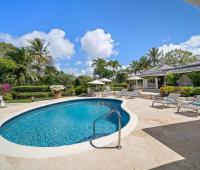 Expansive pool deck at Ixora Villa with lounge chairs, providing a perfect space for sunbathing and enjoying the tropical gardens