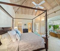 Master bedroom with king-sized four-poster bed and luxurious tropical décor at Ixora, Royal Westmoreland, Barbados
