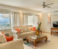 Beachfront Holiday Rental Barbados Palm Beach 410 Living Room with Couches, TV and Aircondition