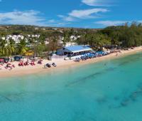 Aerial view of Mullins Beach Club, the exclusive beach facility for Royal Westmoreland guests, with white sand, turquoise waters, and beachfront dining.