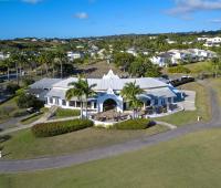 A breathtaking aerial view of Royal Westmoreland’s championship golf course in Barbados, featuring lush fairways, palm-lined greens, and panoramic ocean views.