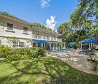 Exterior view of Sandalwood House, a luxury villa in Sandy Lane, Barbados, featuring a private pool and lush tropical gardens.