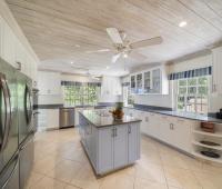 Spacious kitchen at Sandalwood House, featuring a large island, ample storage, and sleek stainless steel appliances.