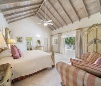 Elegant primary bedroom at Sandalwood House with high vaulted ceilings and access to a private terrace in Sandy Lane.