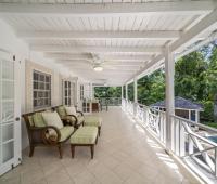 Expansive upper terrace at Sandalwood House with comfortable seating, offering views of the tropical gardens and pool.