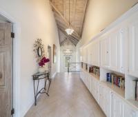 Hallway at Sandalwood House, showcasing built-in bookshelves and a vaulted wooden ceiling.