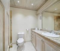 Contemporary bathroom in fourth bedroom at Sandalwood House, offering a stone-tiled shower, spacious vanity, and natural wooden finishes