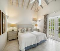 Bedroom Two of Cottage at Sandalwood House with high ceilings, light-filled windows, and direct access to the garden