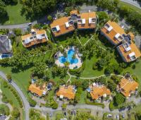 Aerial view of Sugar Hill Resort, Barbados, featuring the lush landscaped grounds, tropical palm trees, and the central pool area, with the Seabreeze Penthouse nestled among luxury villas, showcasing its prime location in this upscale resort.