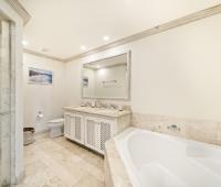 Modern bathroom in Seabreeze Penthouse, Sugar Hill Resort, Barbados, featuring dual sinks, marble countertops, a spacious shower, and a luxurious bathtub, combining functionality with elegant design.