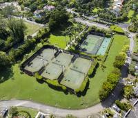 Sugar Hill Resort tennis courts in Barbados, surrounded by manicured lawns and tropical gardens, offering guests at Seabreeze Penthouse ample recreational facilities within the resort’s peaceful environment.