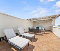 Expansive rooftop lounge at Seabreeze Penthouse, Sugar Hill Resort, Barbados, with comfortable outdoor furniture under a pergola, offering a private and stylish area for entertainment and relaxation with resort views.