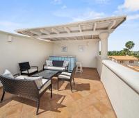 Rooftop lounge area of Seabreeze Penthouse, Sugar Hill Resort, Barbados, with comfortable outdoor seating and a private bar area, perfect for enjoying panoramic views and tropical sunsets.