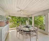 A stylish covered dining area at Seascape, a top-rated beachfront holiday rental villa in Barbados, offering elegant decor and an idyllic setting for meals with ocean views.