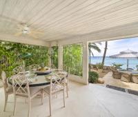 A stylish dining area at Seascape villa in Barbados, offering a seamless indoor-outdoor experience with ocean views, ideal for holiday rental guests seeking beachfront luxury.