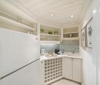 A small but charming wet bar area at Seascape villa in Barbados, complete with a refrigerator, open shelving, and a cozy setup for entertaining during a beachfront holiday rental.