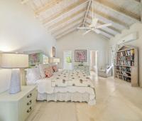 Image of a secondary bedroom with eclectic decor at Seascape, Barbados: A stylish secondary bedroom with artistic accents, a king-size bed, and a vaulted ceiling, offering guests a spacious and comfortable space in this high-end Barbados beachfront rental.