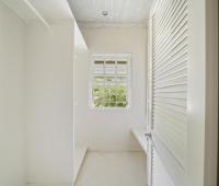 Image of a bright walk-in closet at Seascape, Barbados: A spacious walk-in closet with natural light and minimalist design, offering guests ample storage and a touch of elegance in this luxury beachfront villa in Barbados.