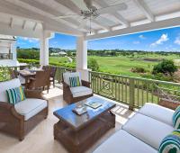Spacious covered patio at Sugar Cane Ridge 22, Royal Westmoreland, featuring outdoor seating and dining with breathtaking golf course views.