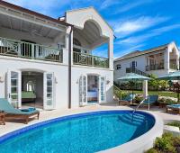 Stunning rear view of Sugar Cane Ridge 22, featuring a private pool, sun loungers, and a covered balcony overlooking the golf course.
