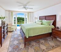 Elegant second bedroom featuring a king-sized bed, garden views, and direct access to the private pool at Sugar Cane Ridge 22.
