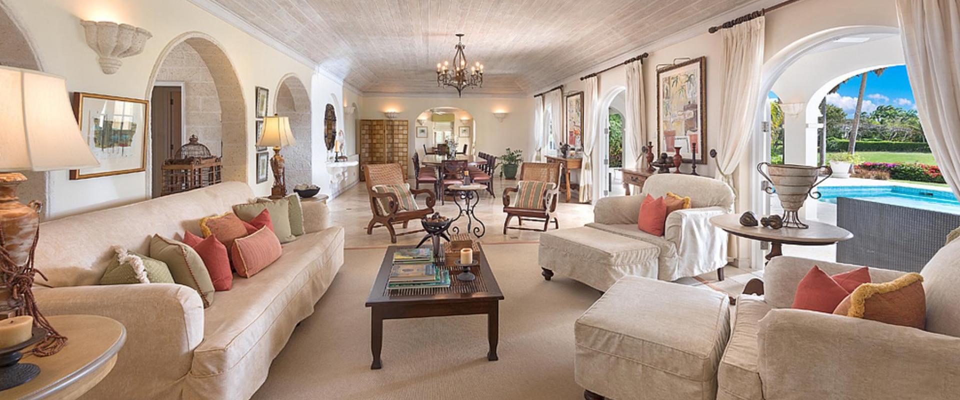 Spacious, elegantly designed living room with vaulted ceilings, plush seating, and open access to the pool at Benjoli Breeze, Barbados.