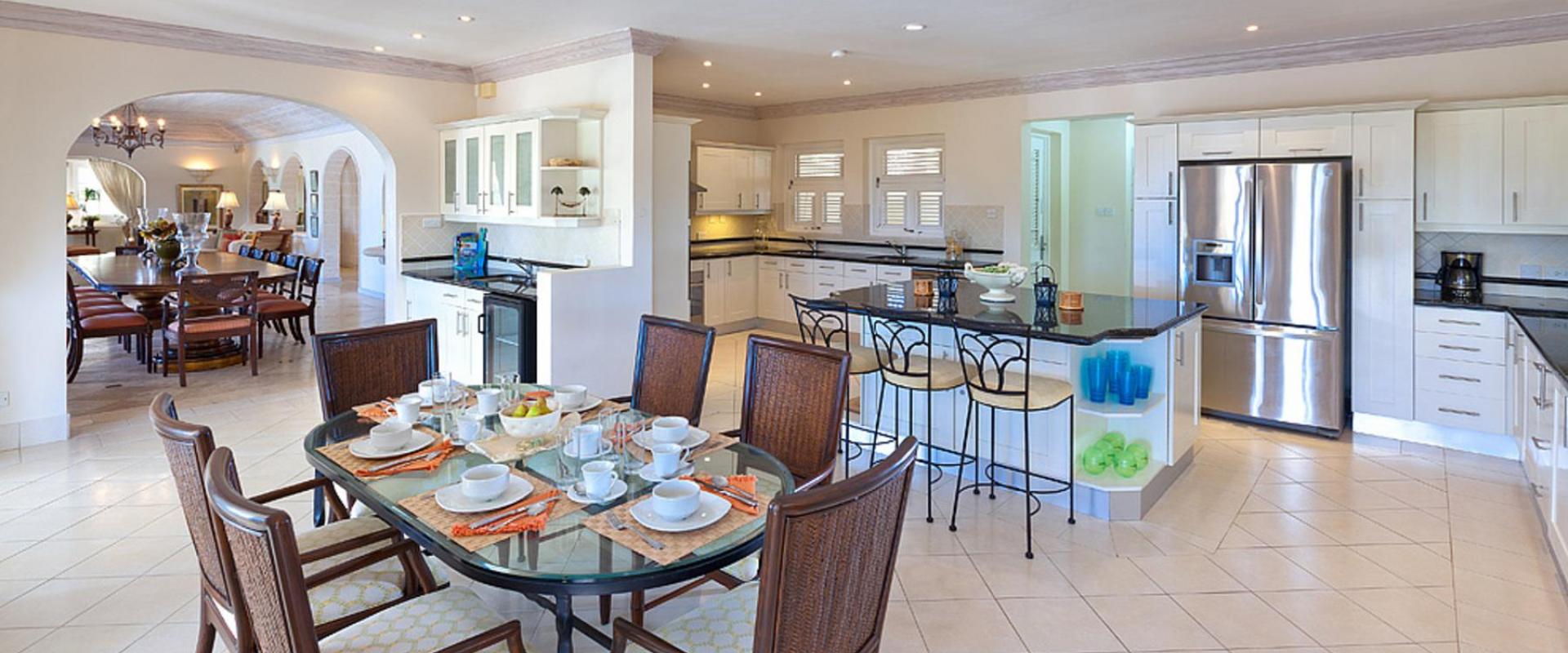 Modern, fully-equipped kitchen with breakfast dining area at Benjoli Breeze, a luxury villa rental in Royal Westmoreland, Barbados.