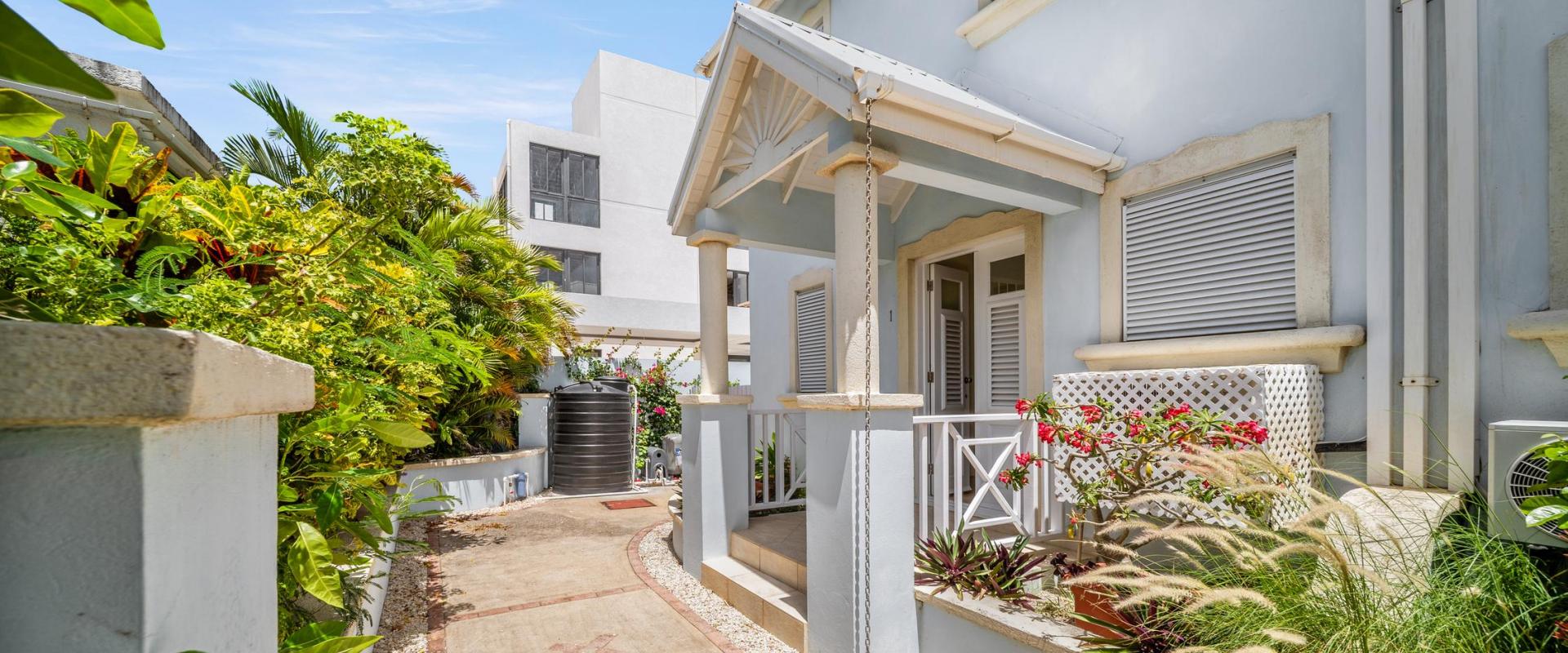 Charming front entrance with tropical landscaping and welcoming porch at Blue Waters 1 holiday rental, steps from Miami Beach Barbados.