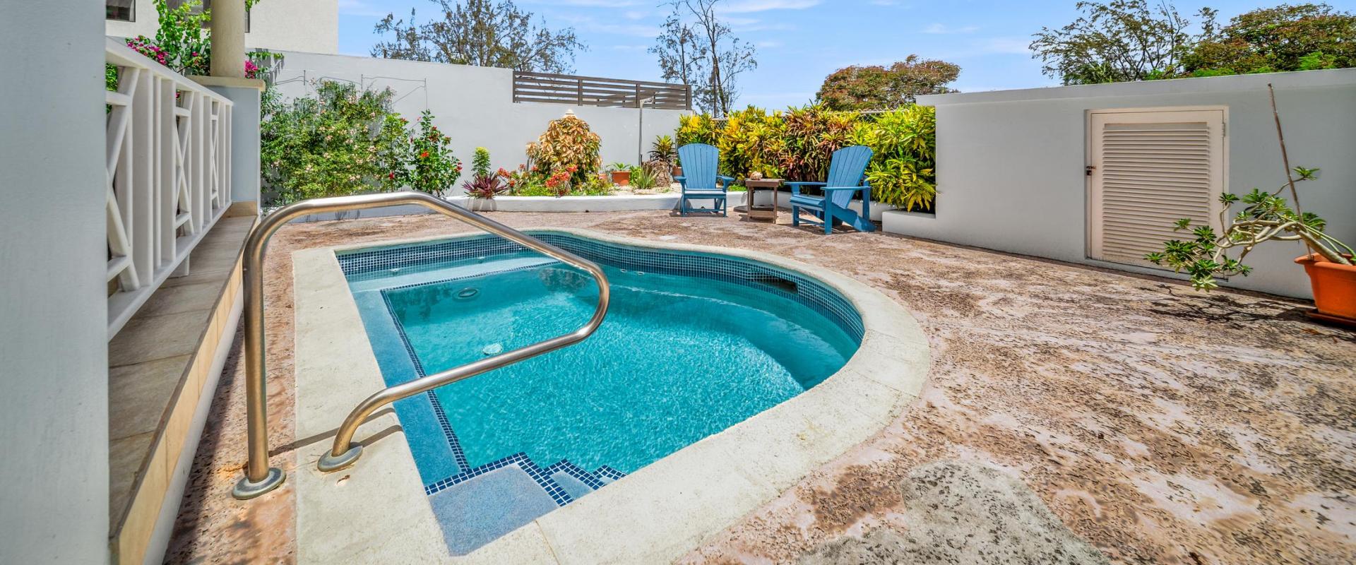 Sparkling private pool surrounded by lush tropical landscaping and sun loungers at Blue Waters 1 holiday home in Enterprise, Christ Church, Barbados.
