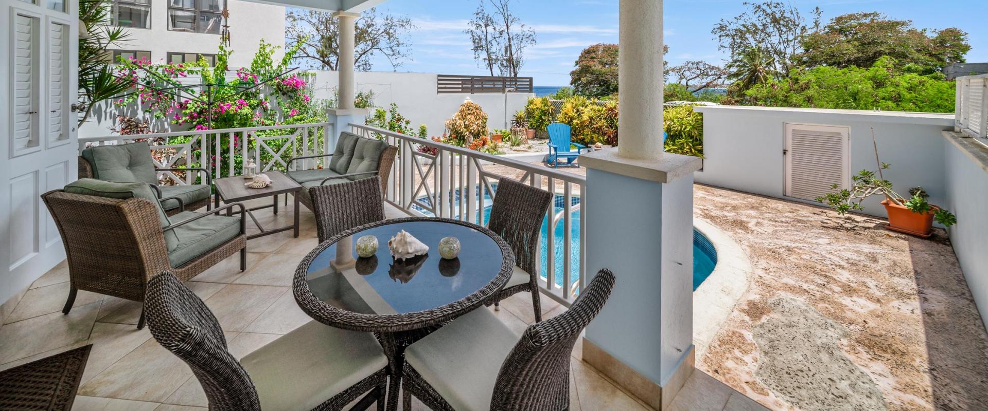 Relaxing covered patio with comfortable outdoor seating overlooking the private pool and garden at Blue Waters 1 ocean view villa in Barbados.