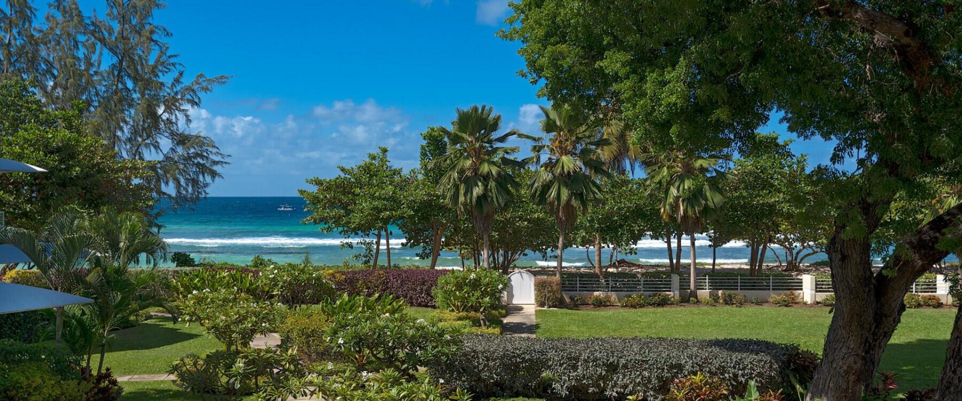 Beautifully landscaped gardens with lush greenery, flowering plants, and shaded walkways leading to the beachfront at Palm Beach 101.